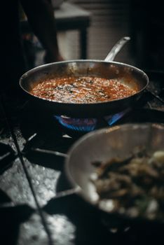 煎锅中番茄酱在煤气炉上煮的特写