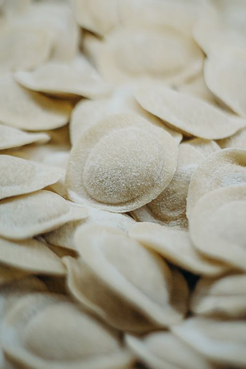 Free A detailed close-up of uncooked pelmeni dumplings stacked, showcasing texture and form. Stock Photo