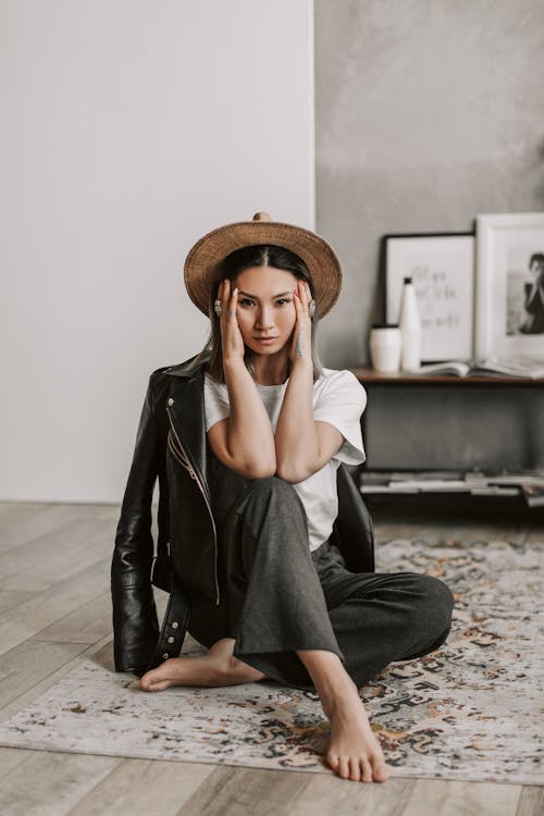 Woman Sitting on a Carpet Holding Her Face