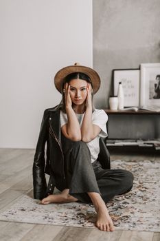 一位身着时尚服装的亚洲女性在室内摆姿，散发着现代气息的时尚与优雅