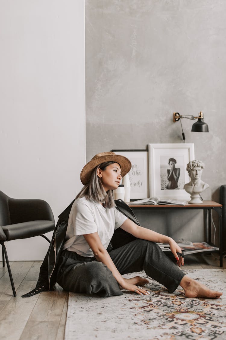 A Woman Sitting On The Living Room Carpet