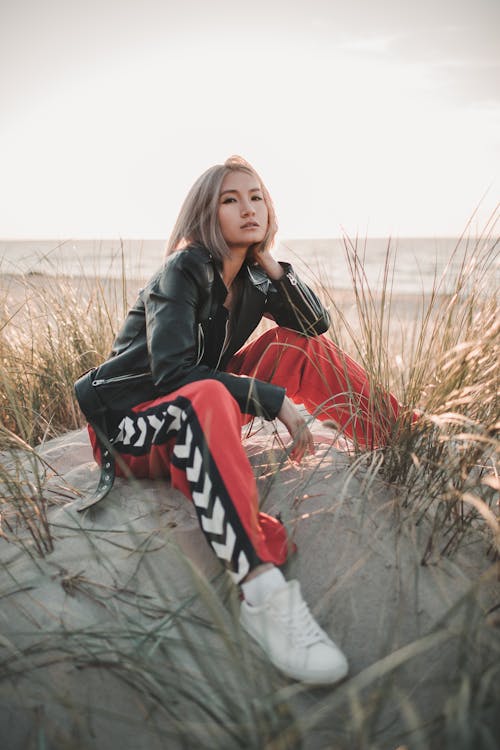 A Woman in Black Leather Jacket and Red Pants