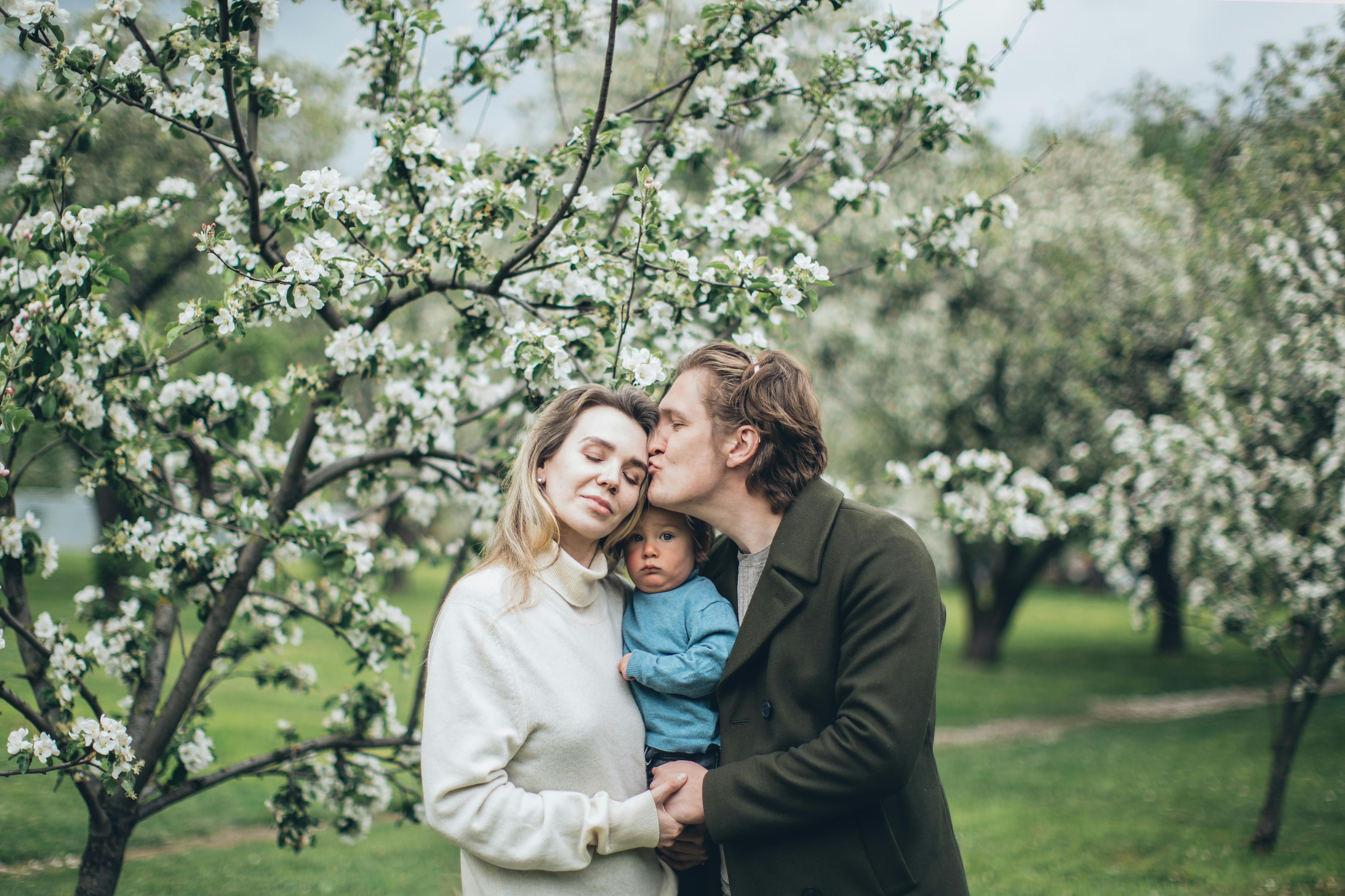 a husband and wife with their child in the park