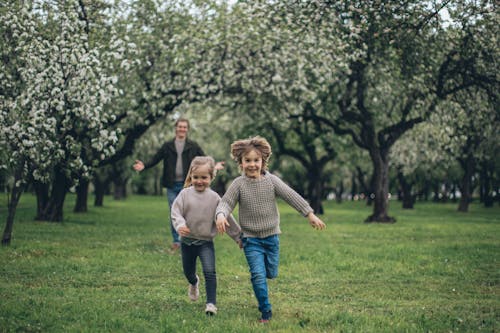 Free Father and Children Running in a Park Stock Photo