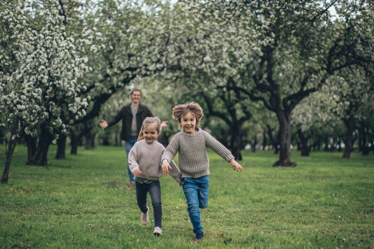 Beautiful Children Running On The Green Grass 