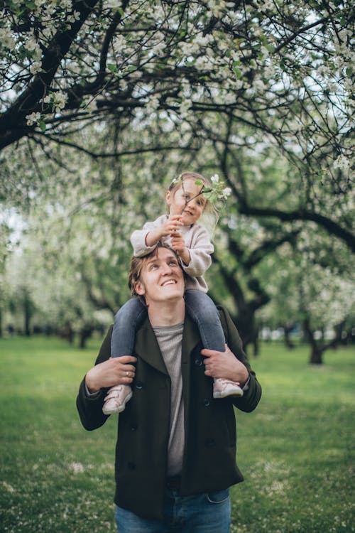 Free A Father Carrying His Daughter on His Shoulders Stock Photo