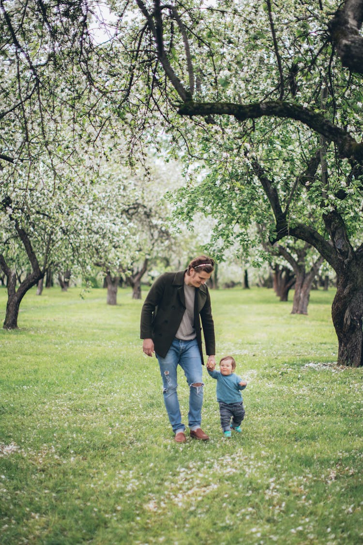 Father Walking With His Baby In The Park