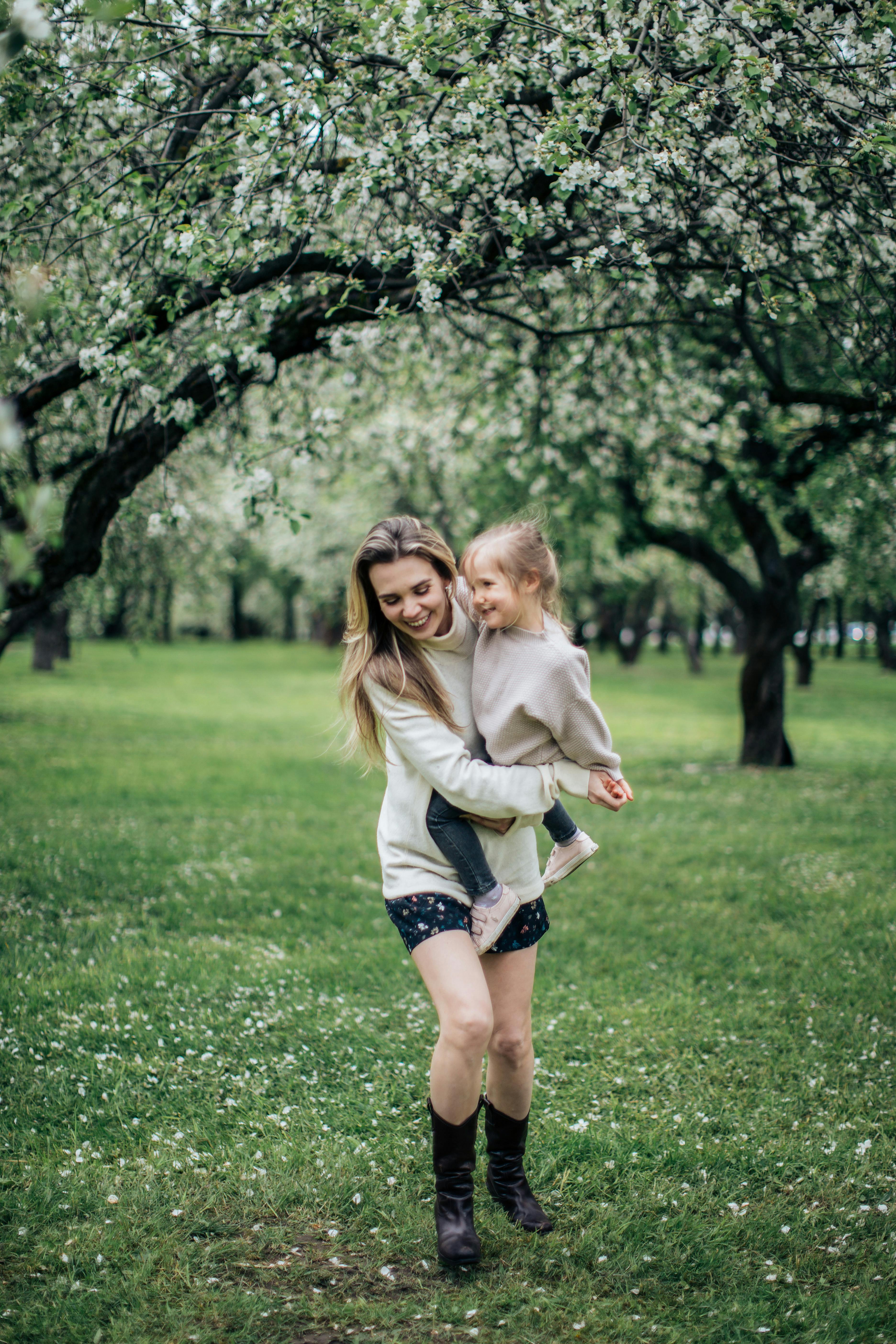 春天果园里鲜花盛开，母女俩享受着欢乐时光