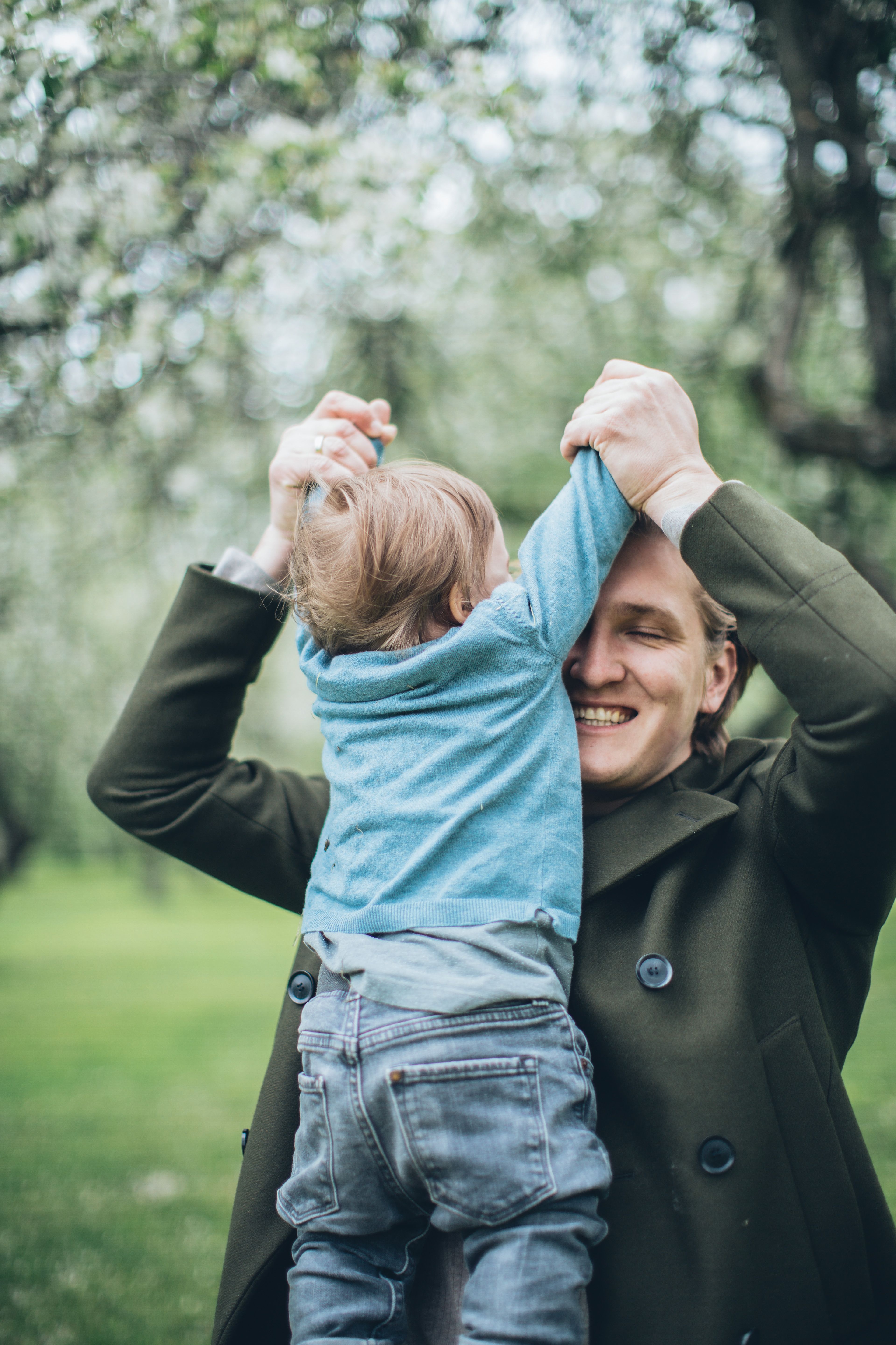 A Smiling Man Carrying his Child on the Shoulders · Free Stock Photo