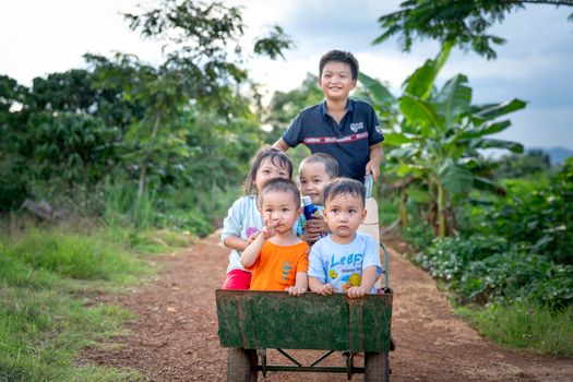 Happy Asian kids having fun together in countryside
