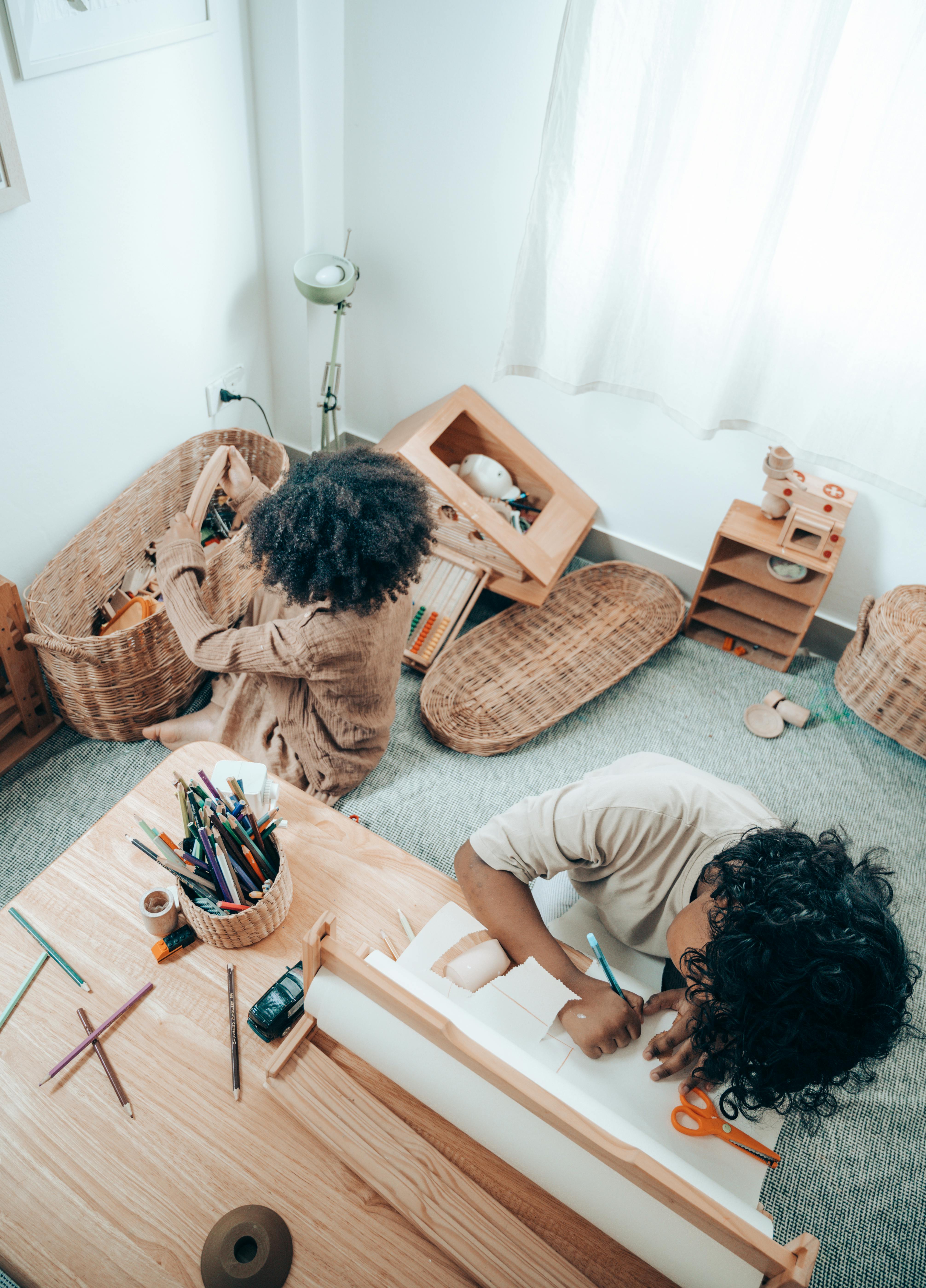 faceless black kids drawing and playing on carpet at home