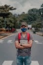 Serious man in face mask on asphalt road