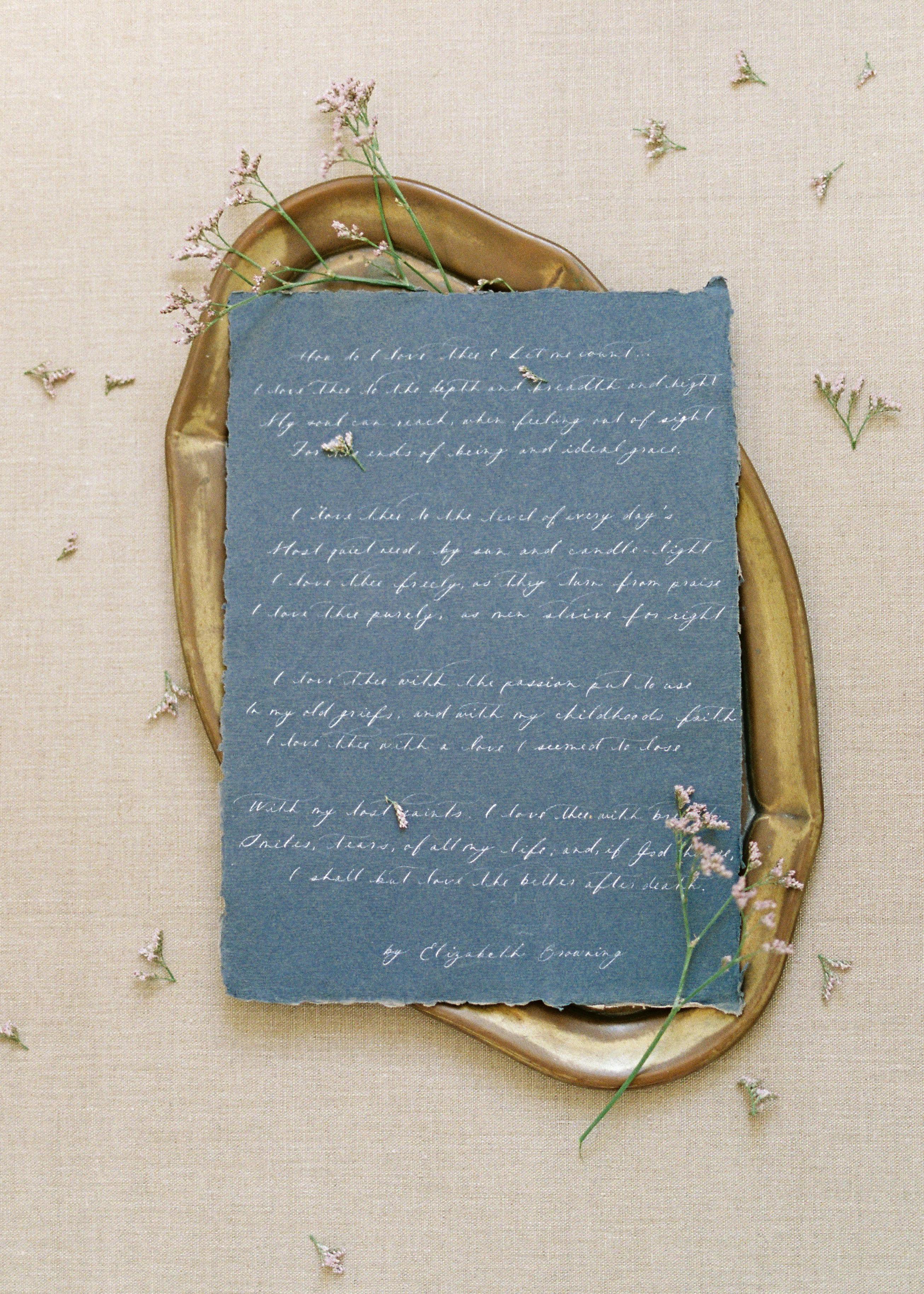 blue sheet of paper with handwriting on brown oval tray