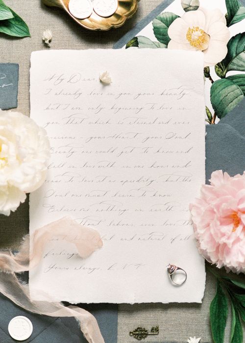 Free Elegant vintage letter surrounded by flowers and decorative items, evoking nostalgia. Stock Photo