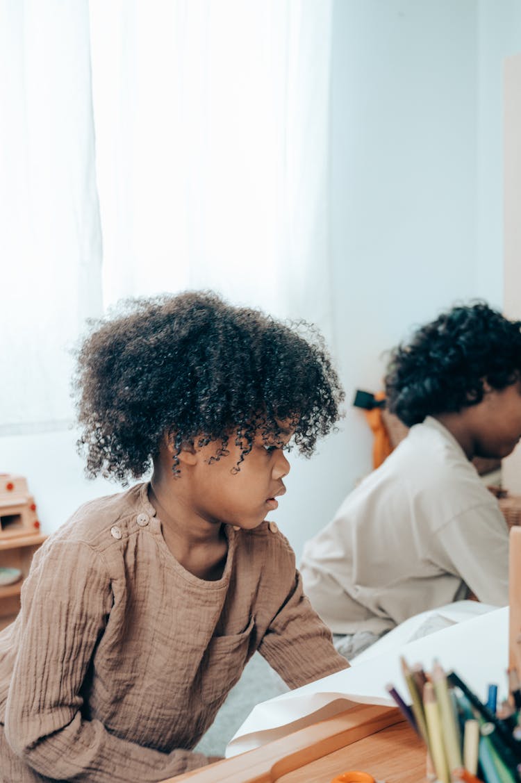 Ponder Black Child Sitting Near Crop Anonymous Sister At Home