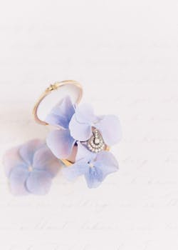 以新娘为主题的精致珠宝作品，优雅地展示在柔软的紫色花瓣上