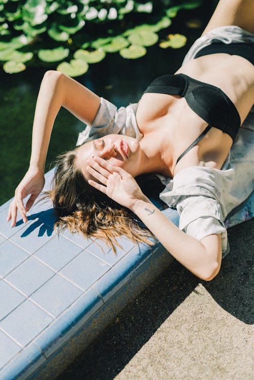 Femme En Soutien Gorge Noir Allongé Sur Des Carreaux De Céramique Blanche