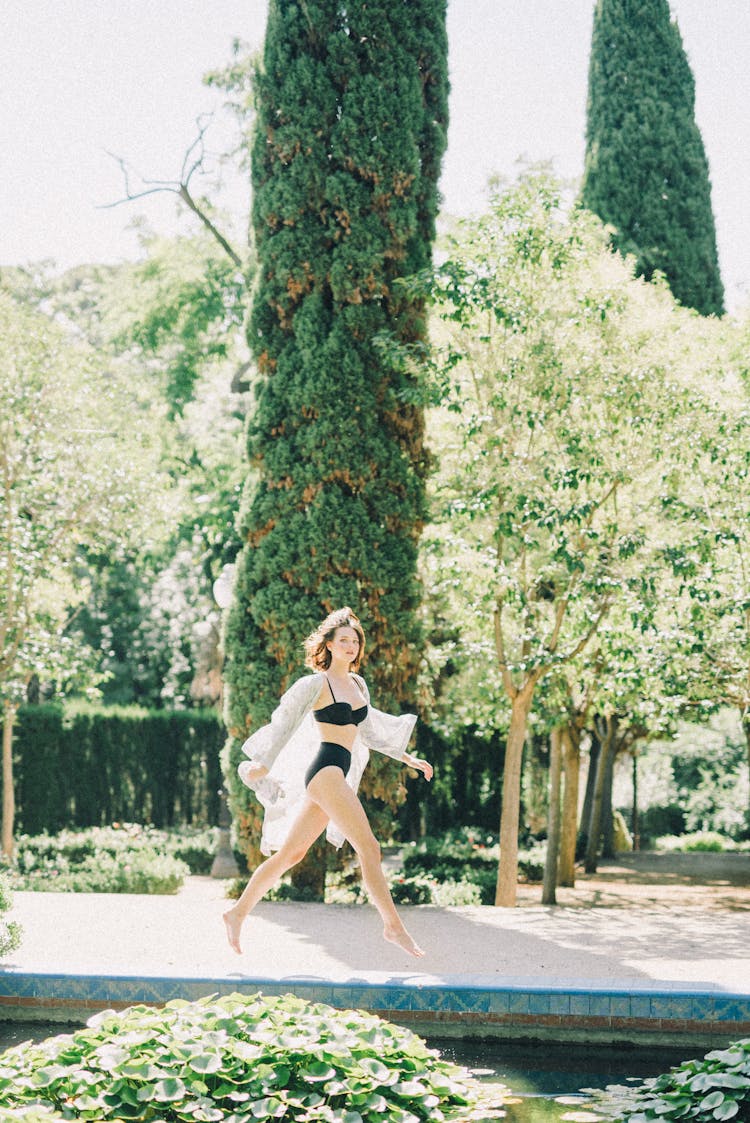 Woman Wearing Black Bikini In A Garden 