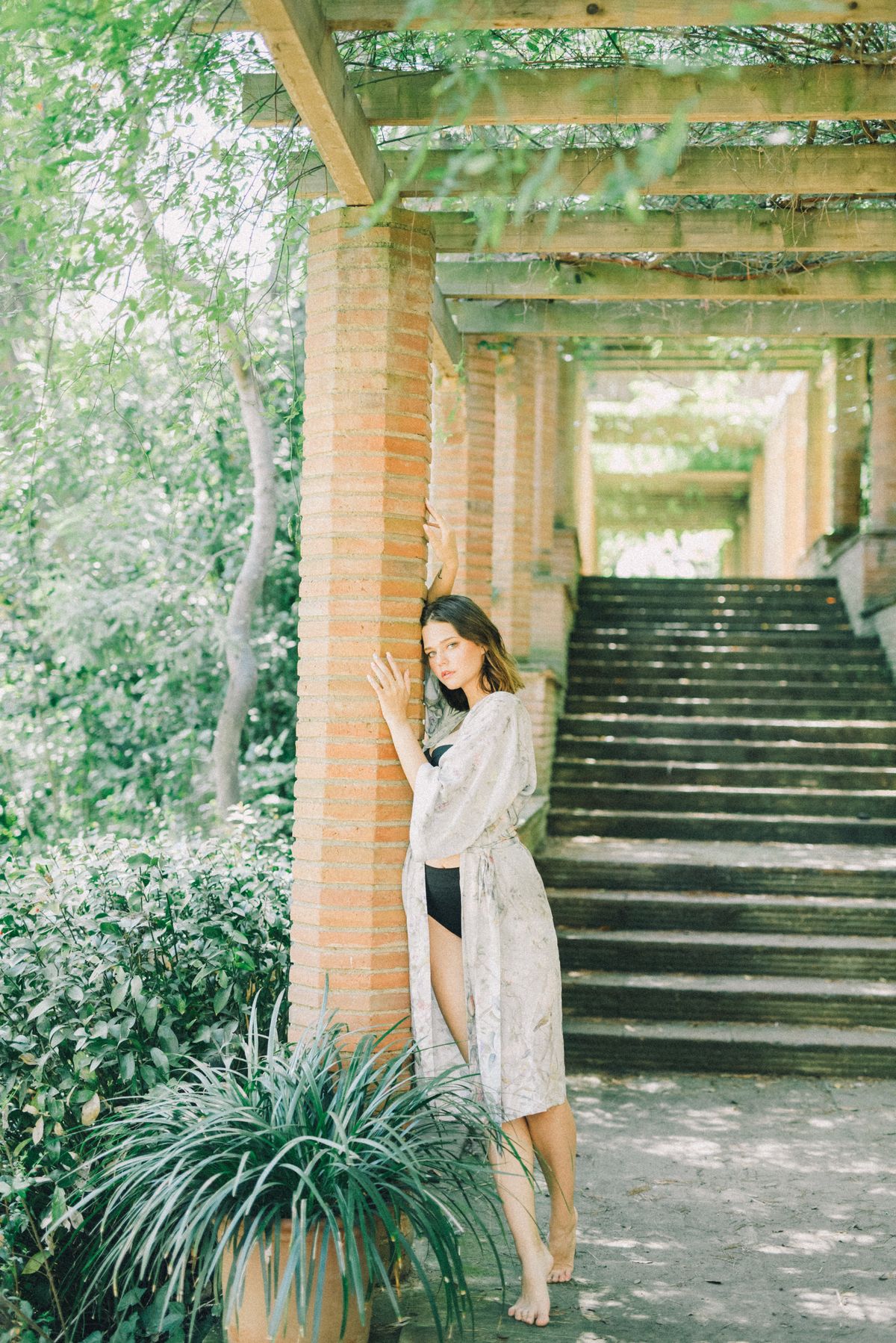 A woman leaning on a column in a cover-up — the elegant beach cover-up