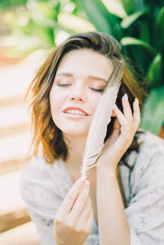 一个女人在户外轻轻地拿着羽毛，享受着宁静的时刻