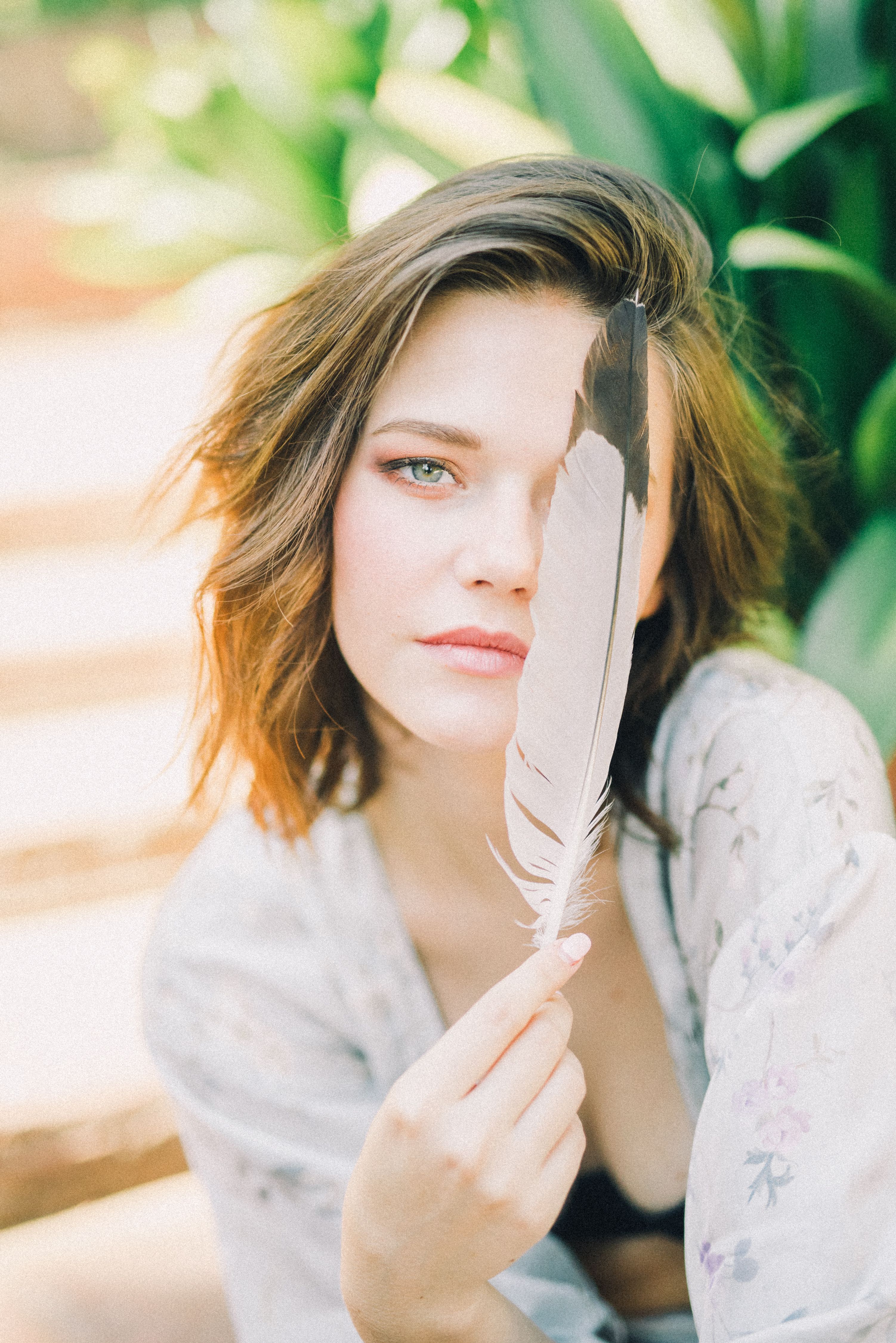 Woman Holding a Feather · Free Stock Photo