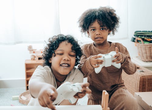 Happy African American girls playing video game console at home
