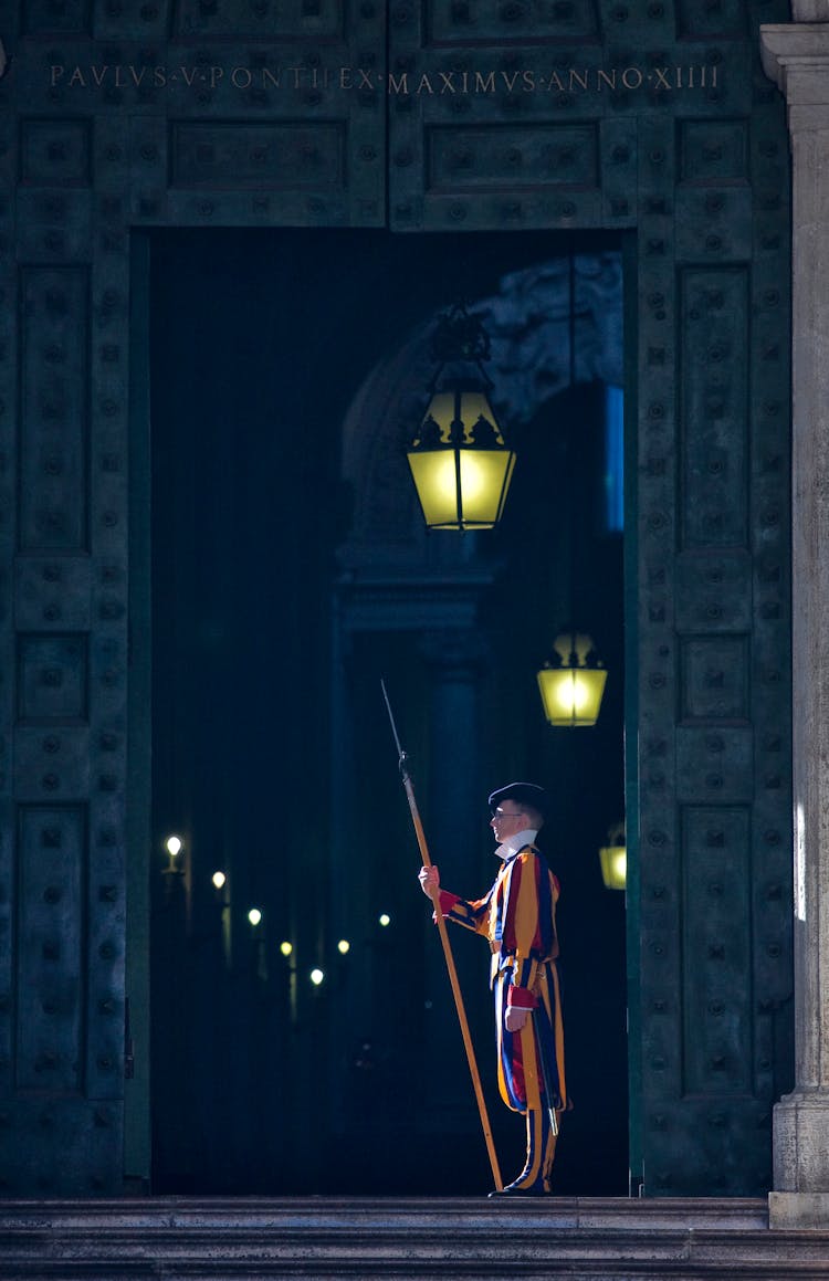 Guard Protecting Entrance Of Aged Building At Night