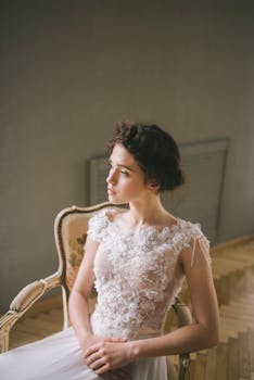 新娘穿着精致的婚纱，优雅地坐在室内的老式椅子上