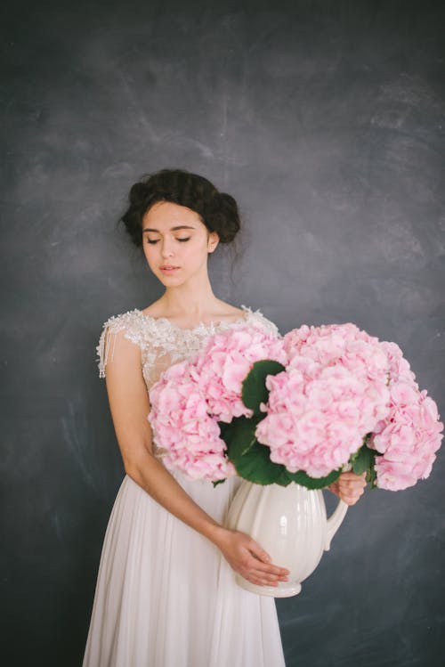 Vrouw In Witte Jurk Met Roze Bloemboeket