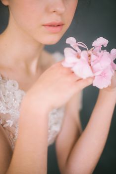 一位女子手持粉色绣球花的局部特写，尽显优雅与女性气质