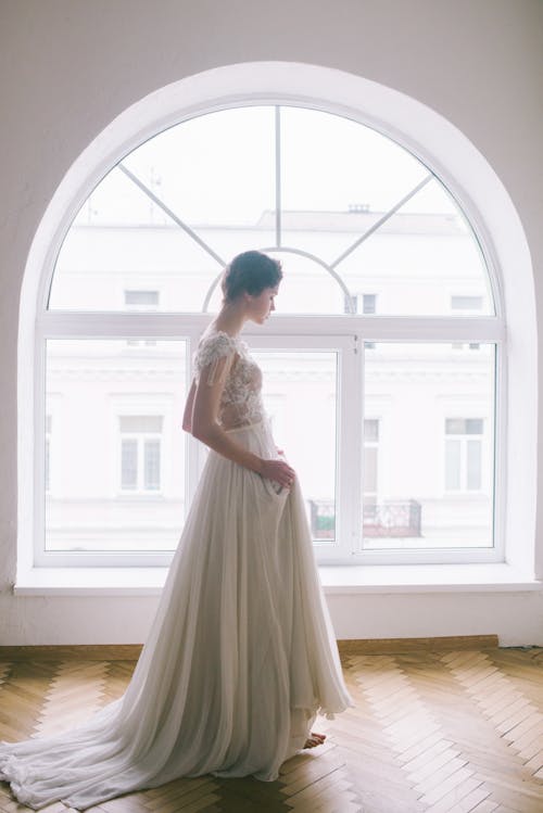 Elegant young lady walking along window