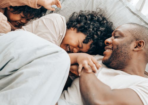 Happy black children playing with dad