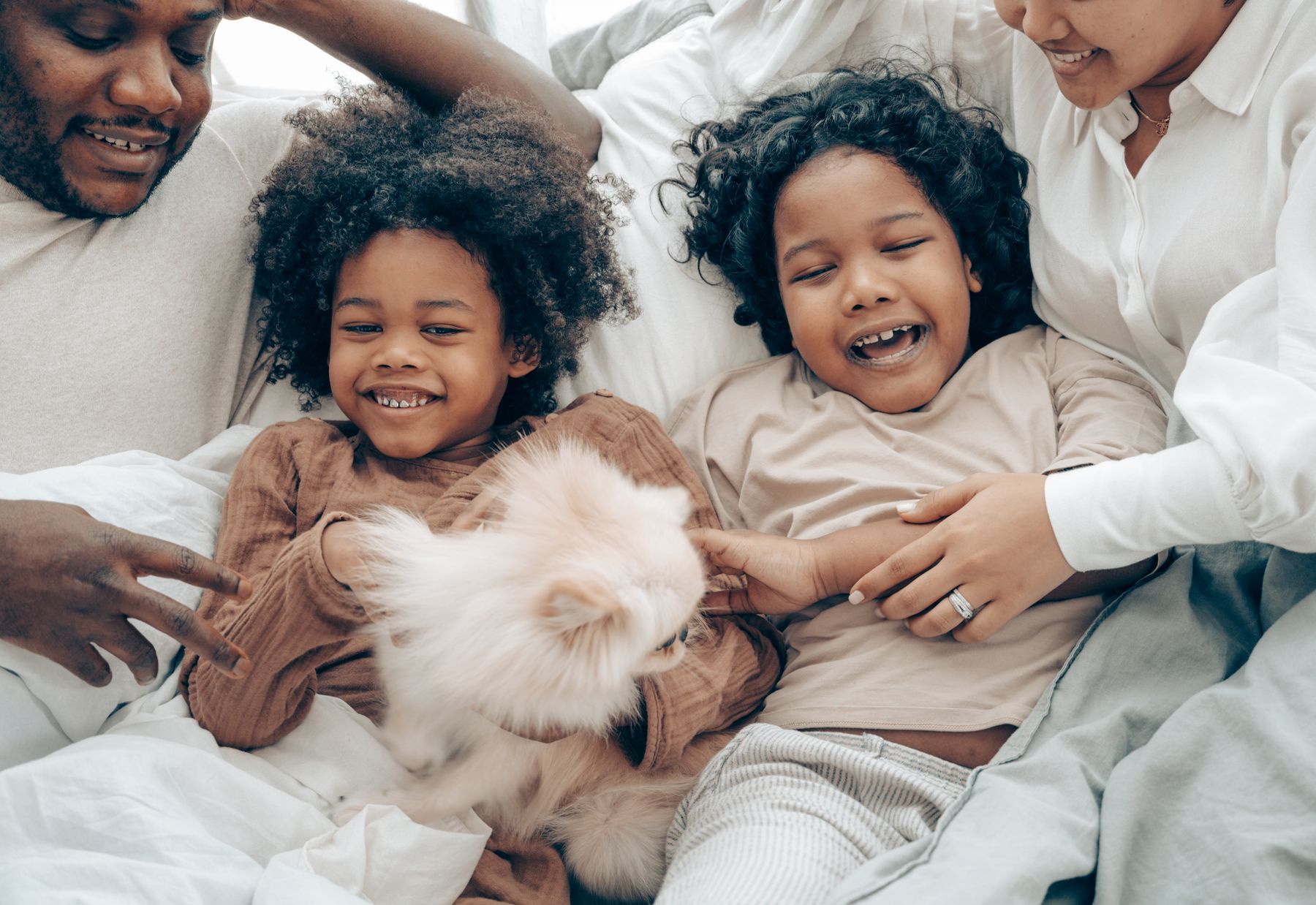 A smiling family relaxing with their pet dog at home