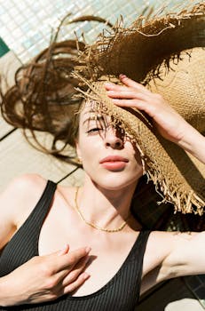 一个女人戴着草帽在户外放松，享受着夏日的阳光