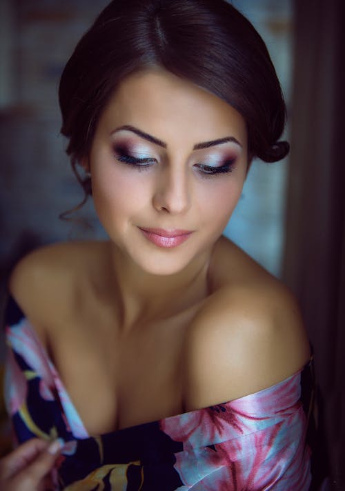 Crop charming feminine woman with bright makeup at home
