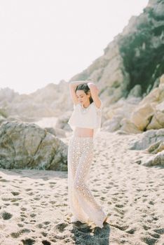 一位身着蕾丝衣裙的女子，正在岩石海滩上享受阳光明媚的一天