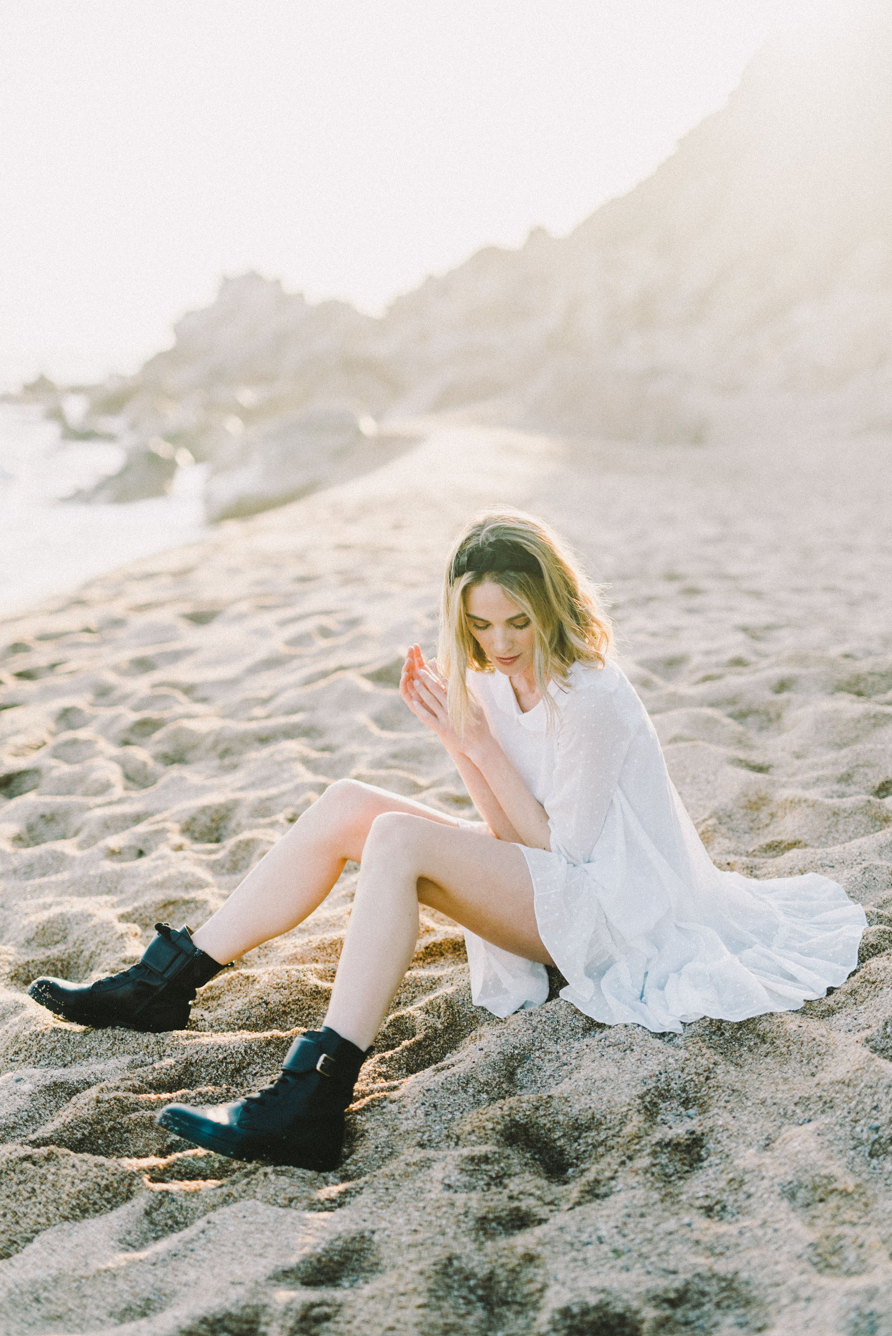 A Young Woman in a White Dress Sitting on the Beach · Free Stock Photo