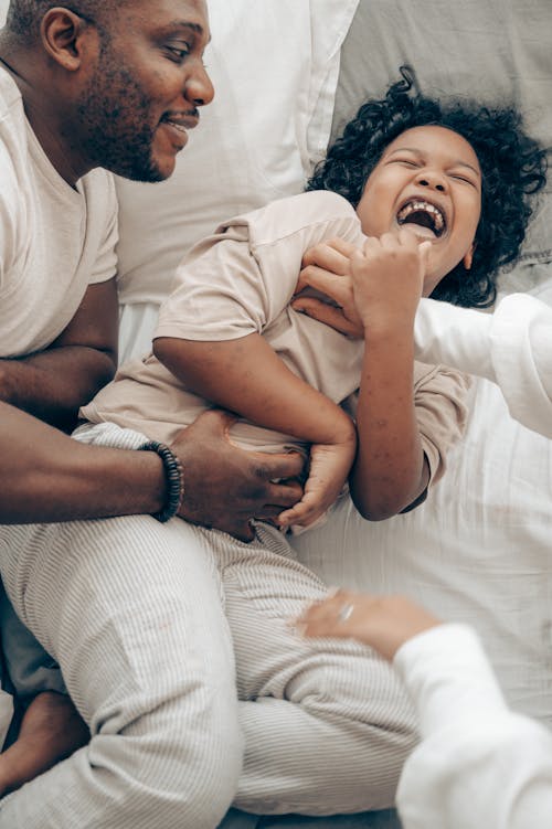 Cute black kid laughing while playing with father