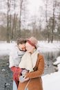 冬日公园静谧安宁，一对夫妇在白雪皑皑的湖边深情相拥
