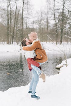 A happy couple enjoys a romantic moment by a snow-covered lake in winter.