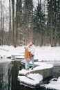 在宁静的冬季公园里，一对夫妇在白雪覆盖的河边拥抱