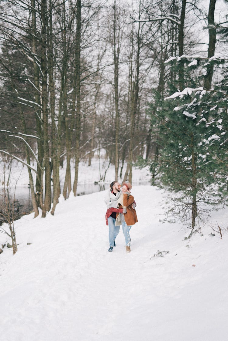 A Happy Couple Walking In A Winter Forest