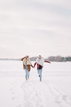一对幸福的夫妇手牵着手，穿过白雪皑皑的风景，尽享冬日之趣