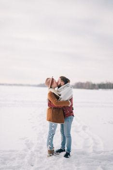 在白雪皑皑的宁静风景中，一对夫妇分享着温暖的拥抱和亲吻