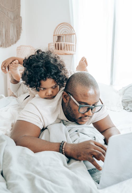Free Father Working From Home With Child on His Back Stock Photo
