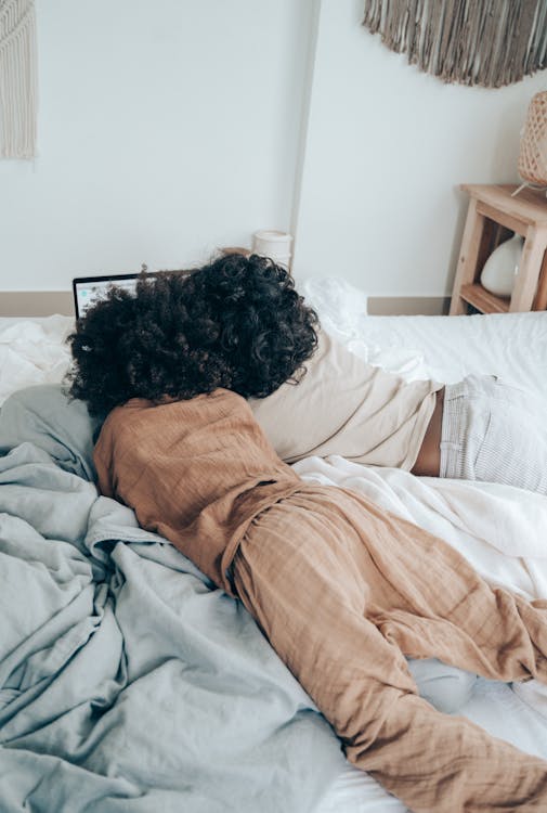 Children lying on bed with laptop