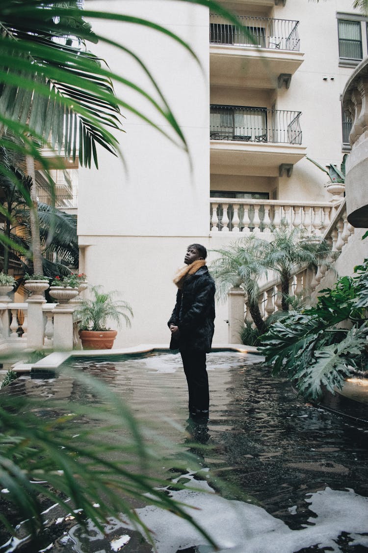 Man In Black Jacket Standing On Water Fountain