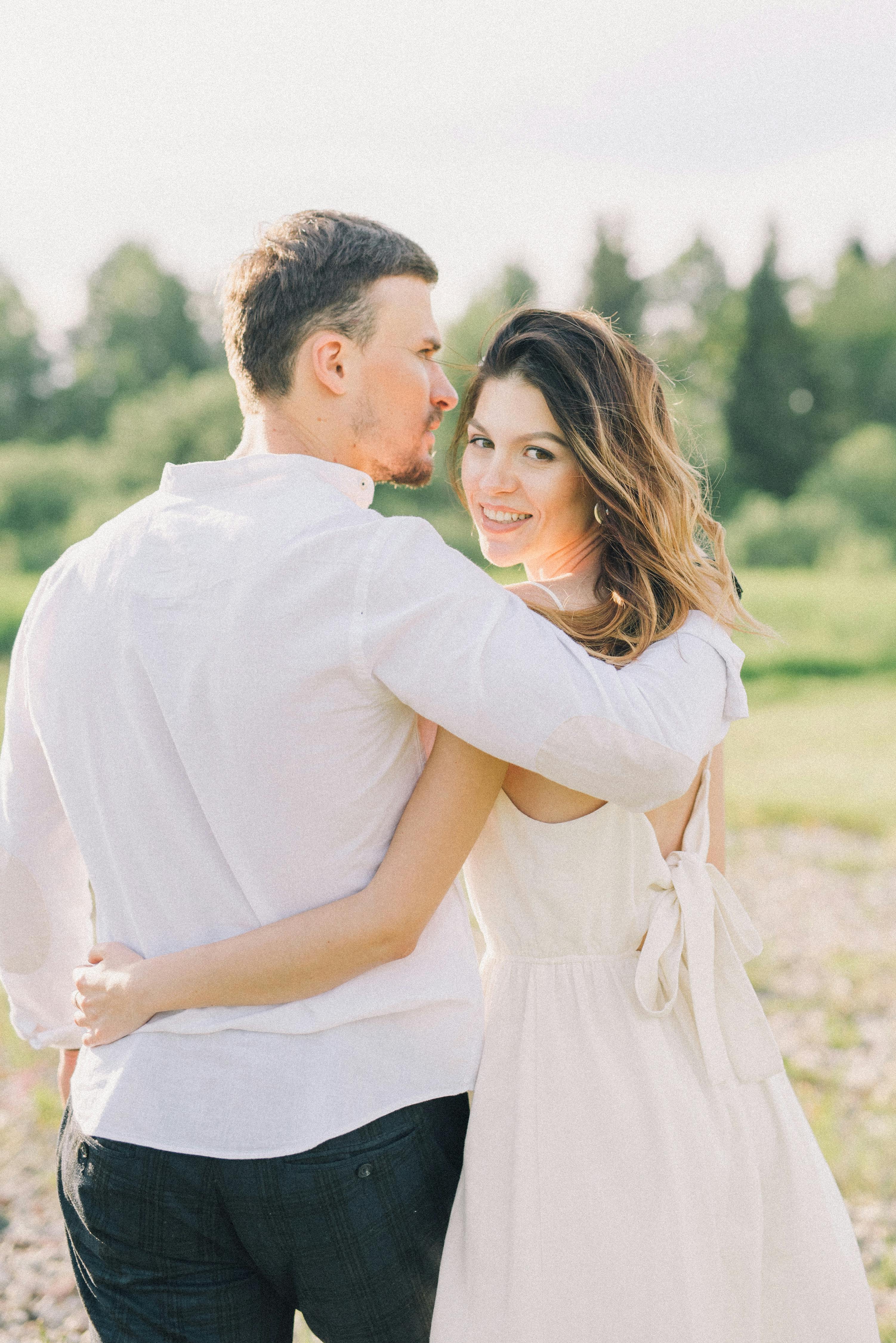 一对夫妇在绿色的田野上相拥，捕捉到了幸福而深情的时刻