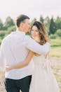 一对夫妇在绿色的田野上相拥，捕捉到了幸福而深情的时刻
