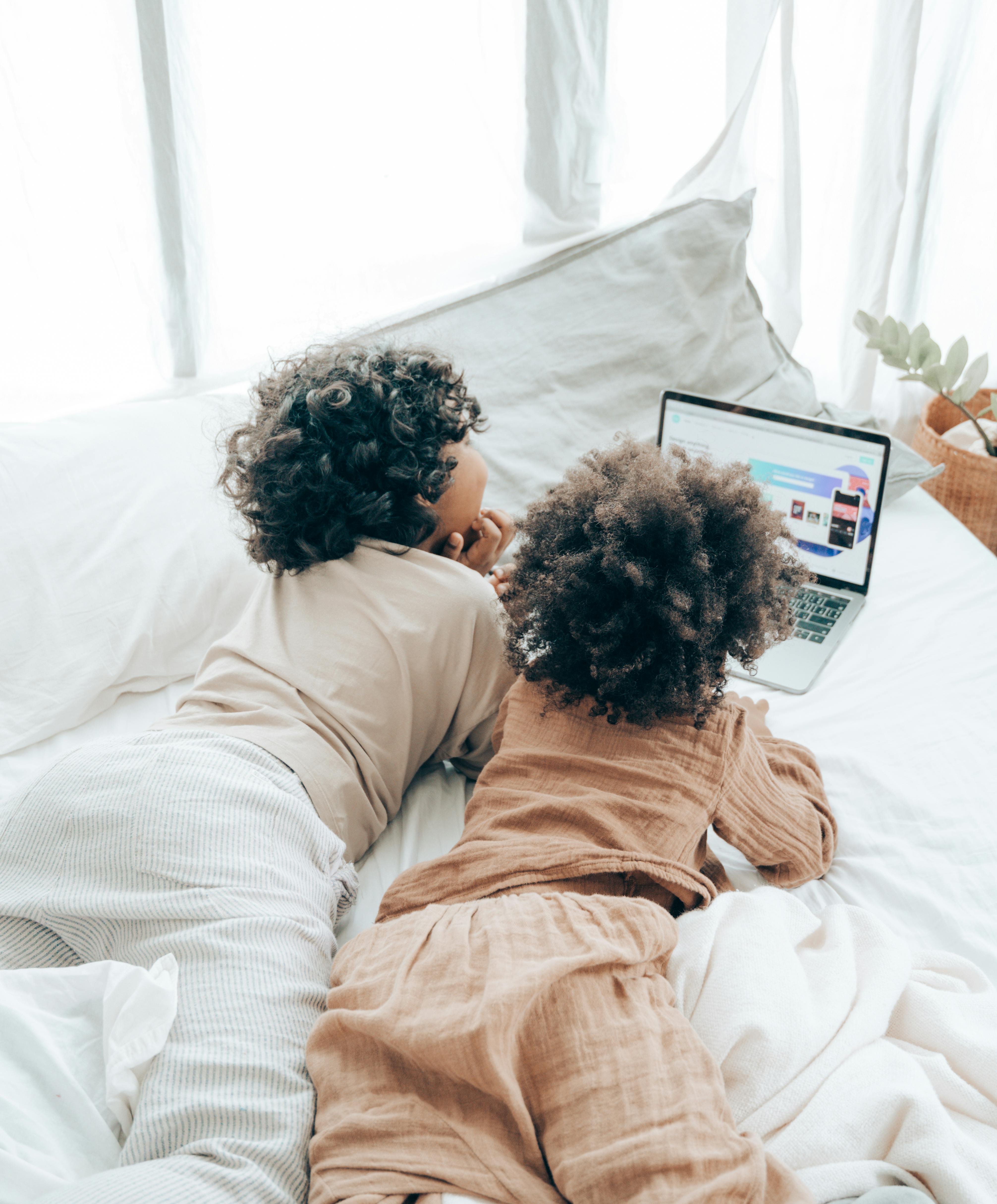 little brothers using laptop on bed